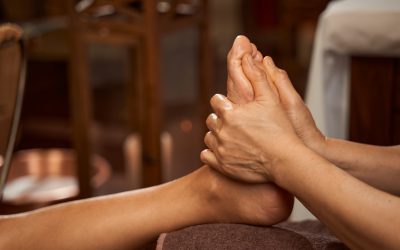 Skilled reflexologist performing reflexology massage using thumbs